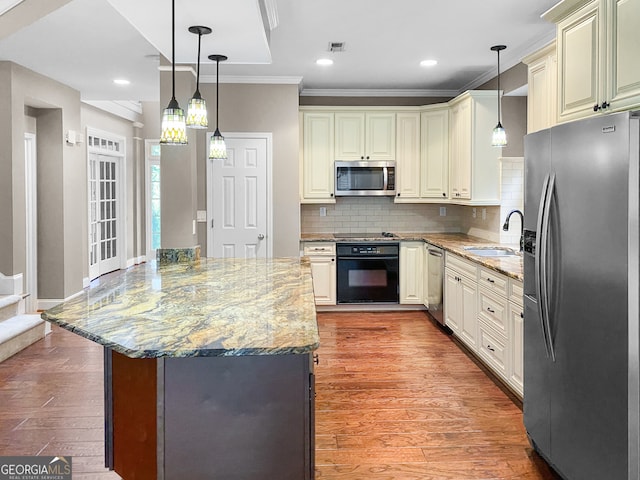 kitchen with light wood-type flooring, sink, light stone counters, hanging light fixtures, and black appliances