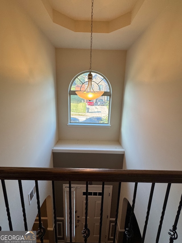 staircase featuring a raised ceiling