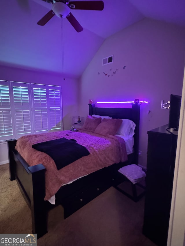 carpeted bedroom with ceiling fan and vaulted ceiling