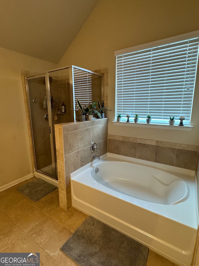 bathroom featuring shower with separate bathtub, vaulted ceiling, and tile patterned flooring