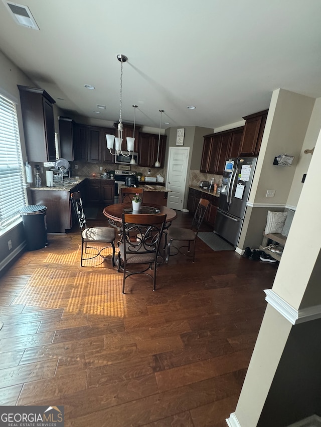 dining space featuring a notable chandelier and dark hardwood / wood-style flooring