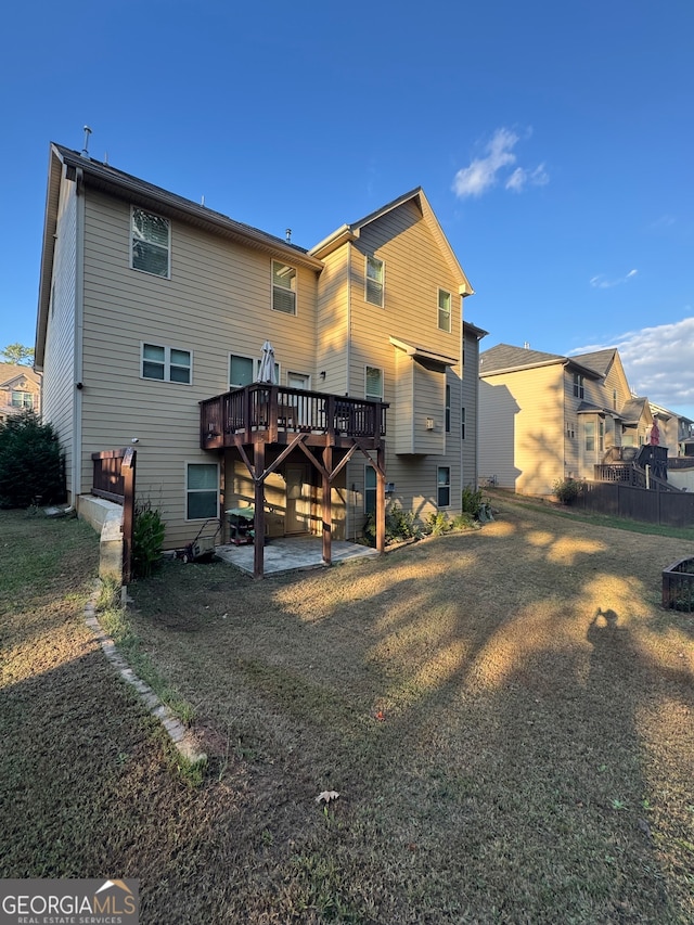 rear view of property featuring a yard, a deck, and a patio area