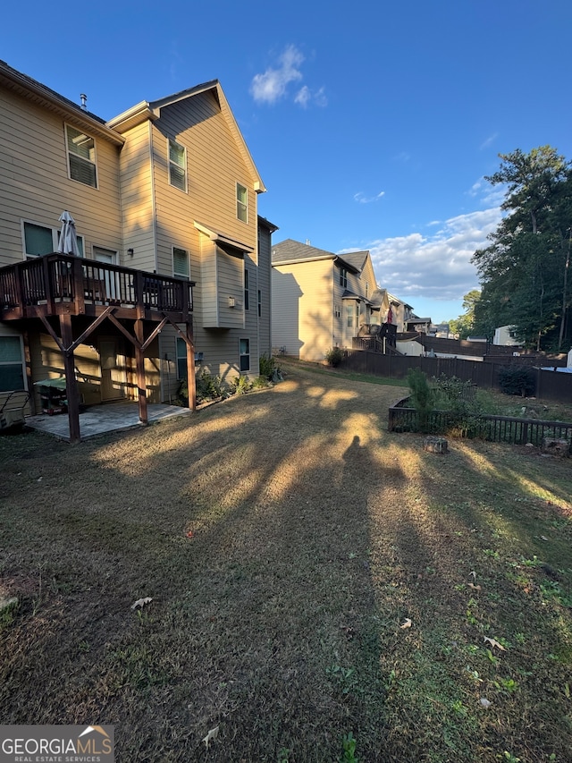 rear view of property with a wooden deck and a lawn