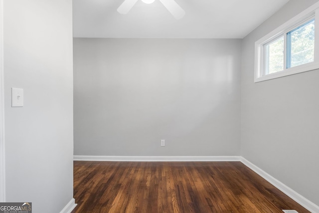 empty room with ceiling fan and dark hardwood / wood-style flooring