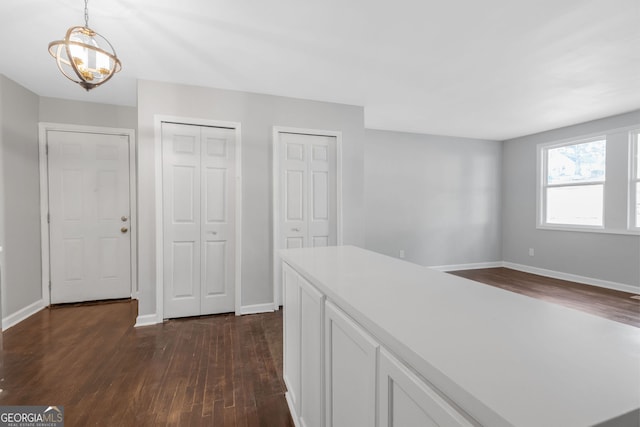 hallway with an inviting chandelier and dark hardwood / wood-style floors