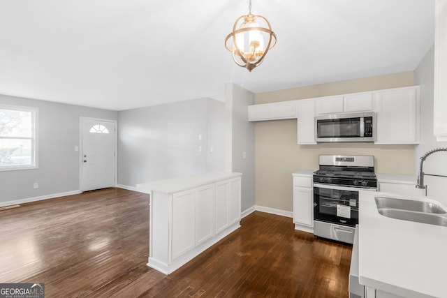 kitchen featuring pendant lighting, white cabinets, sink, dark wood-type flooring, and appliances with stainless steel finishes