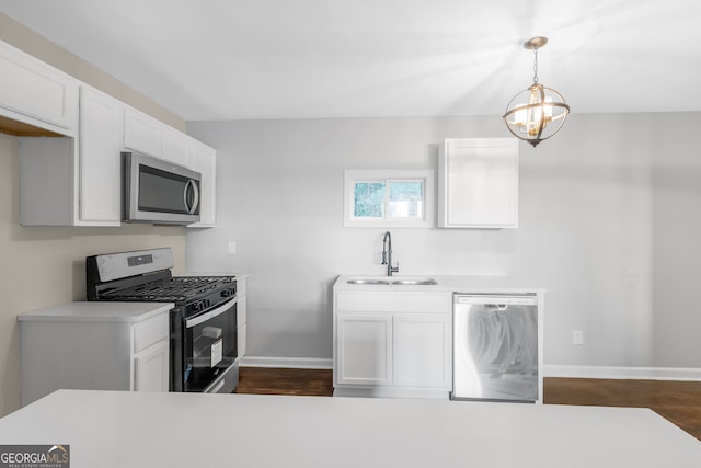 kitchen with dark hardwood / wood-style flooring, sink, stainless steel appliances, hanging light fixtures, and white cabinets