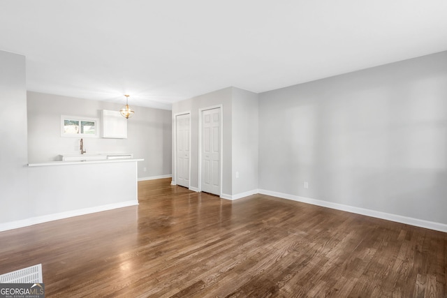 empty room featuring dark hardwood / wood-style floors and an inviting chandelier