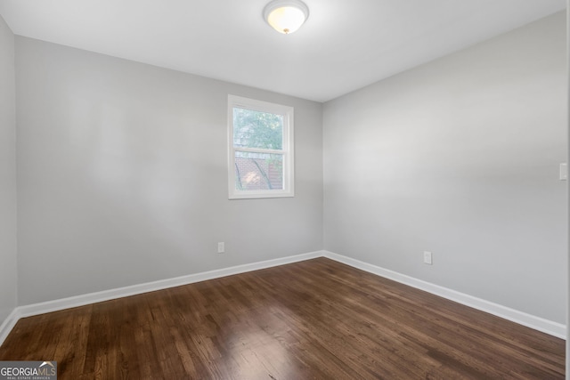 unfurnished room featuring dark wood-type flooring