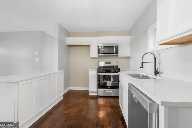 kitchen featuring dark hardwood / wood-style floors, white cabinets, appliances with stainless steel finishes, and sink