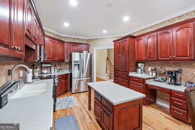 kitchen featuring light wood-type flooring, stainless steel appliances, tasteful backsplash, sink, and crown molding