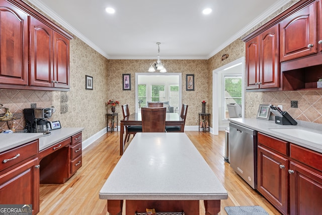 kitchen featuring ornamental molding, pendant lighting, stainless steel dishwasher, and light hardwood / wood-style flooring