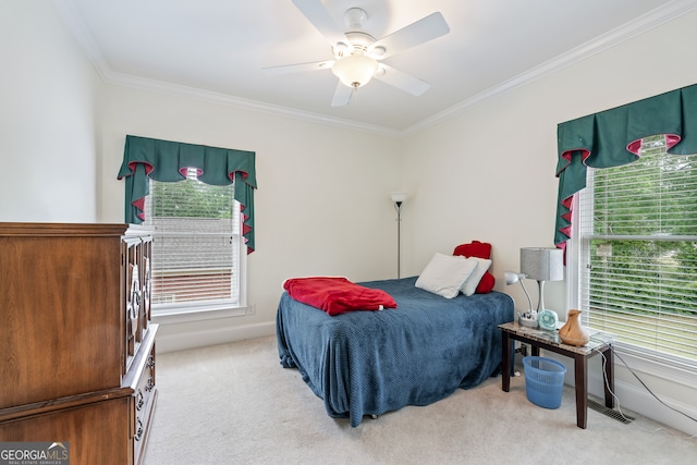 bedroom featuring light carpet, ornamental molding, multiple windows, and ceiling fan