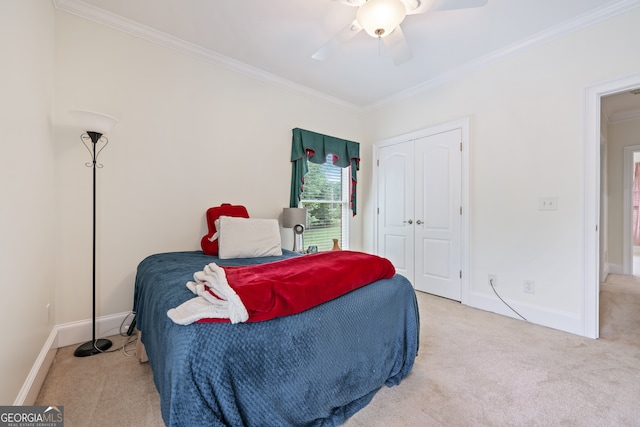 bedroom featuring ornamental molding, ceiling fan, a closet, and carpet flooring