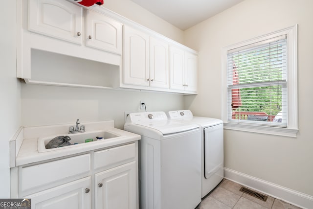 laundry area with light tile patterned floors, cabinets, sink, and washing machine and dryer