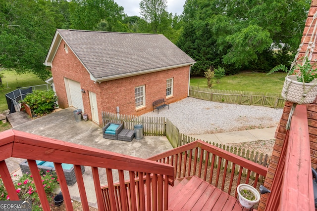 deck featuring a patio area, a lawn, and a garage