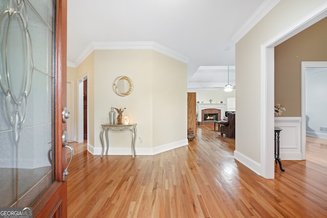 entryway featuring ceiling fan, crown molding, and light hardwood / wood-style floors