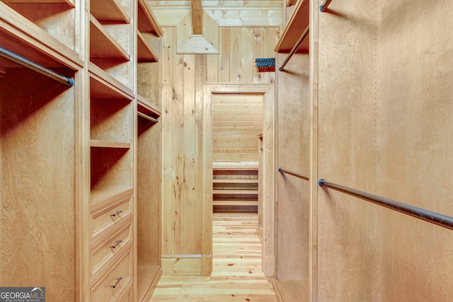 walk in closet with light hardwood / wood-style floors