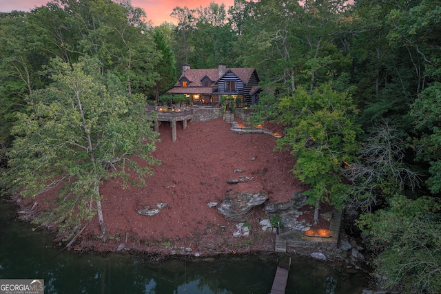 aerial view at dusk featuring a water view