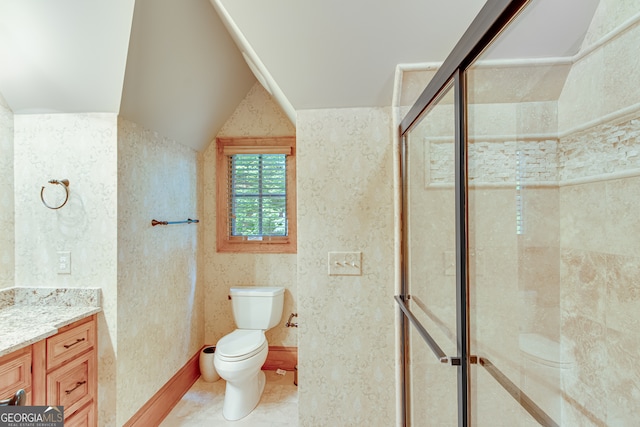 bathroom featuring vanity, lofted ceiling, toilet, and a shower with door