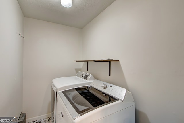 washroom with washing machine and clothes dryer and a textured ceiling