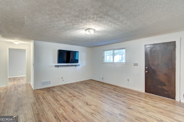 interior space with a textured ceiling and light hardwood / wood-style flooring