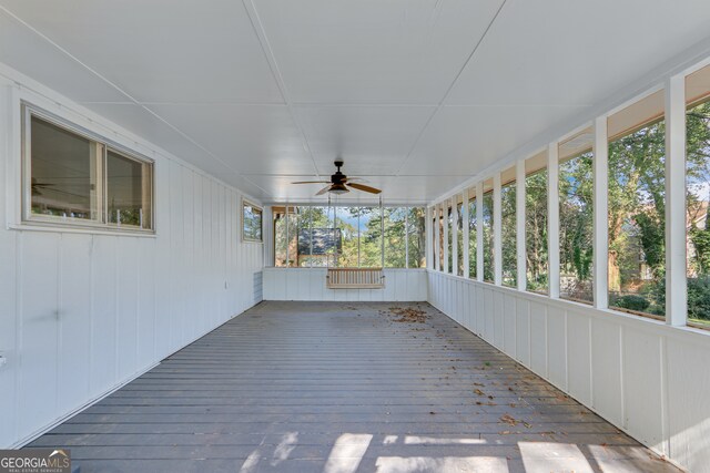 unfurnished sunroom with ceiling fan