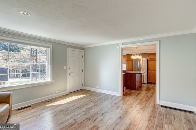 unfurnished living room with ornamental molding, a textured ceiling, a chandelier, and light hardwood / wood-style flooring