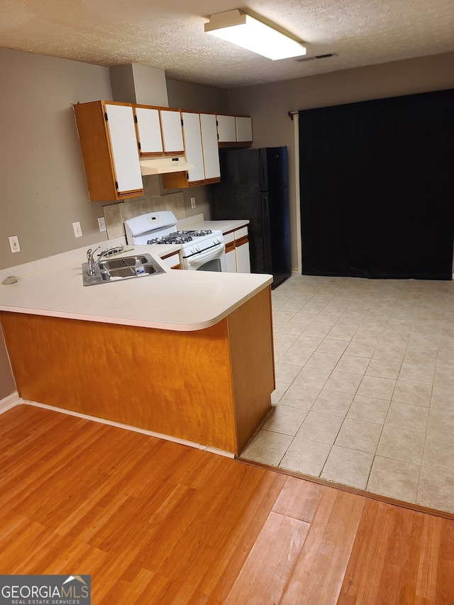 kitchen featuring kitchen peninsula, white range with gas cooktop, white cabinetry, and sink