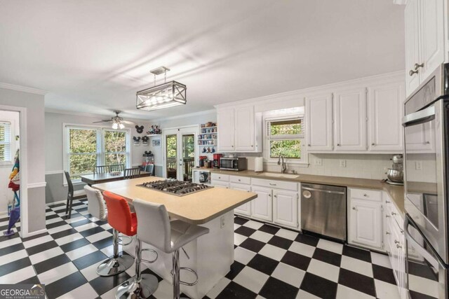 kitchen with a center island, white cabinetry, sink, and stainless steel appliances