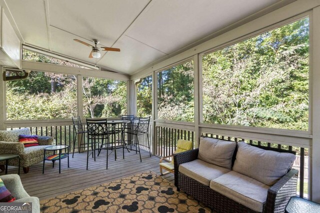 sunroom / solarium with a healthy amount of sunlight, ceiling fan, and vaulted ceiling