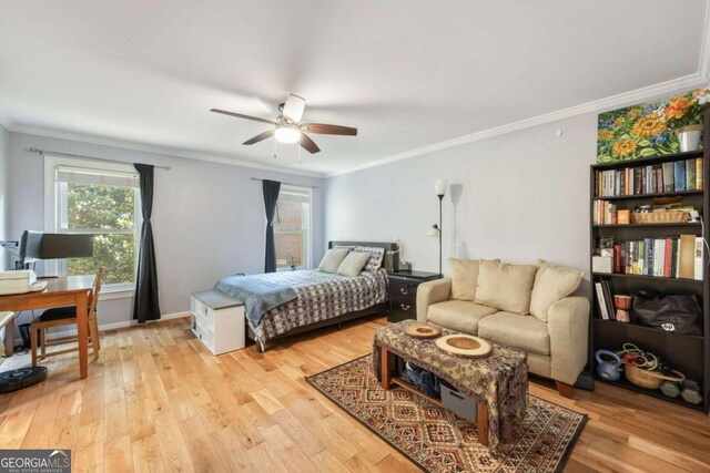 bedroom with crown molding, light hardwood / wood-style flooring, and ceiling fan