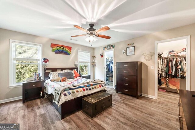 bedroom with a spacious closet, a closet, and ceiling fan