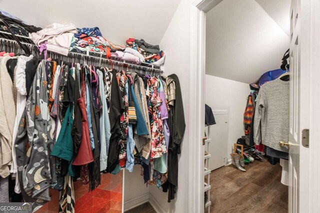 walk in closet featuring lofted ceiling and dark hardwood / wood-style floors