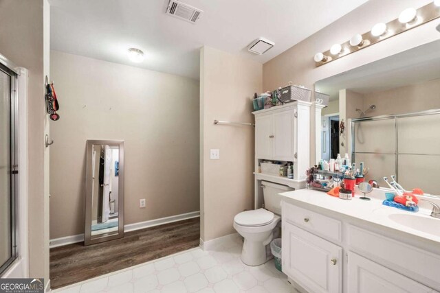 bathroom with toilet, vanity, hardwood / wood-style floors, and walk in shower