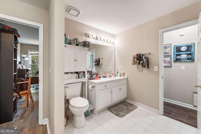 bathroom with hardwood / wood-style flooring, vanity, and toilet