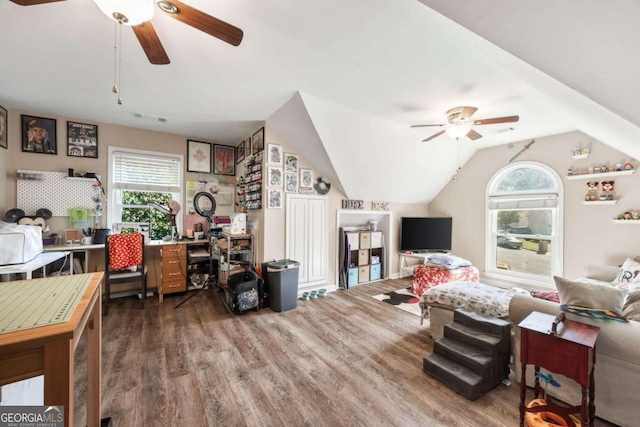 living room with ceiling fan, a wealth of natural light, dark wood-type flooring, and vaulted ceiling