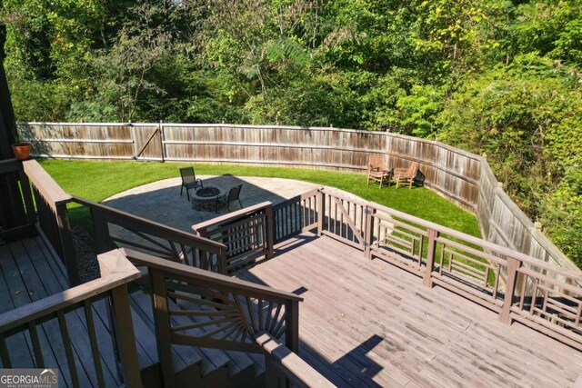 wooden terrace featuring a fire pit and a yard