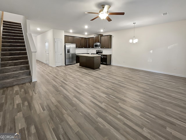 kitchen with appliances with stainless steel finishes, a kitchen island, and wood-type flooring