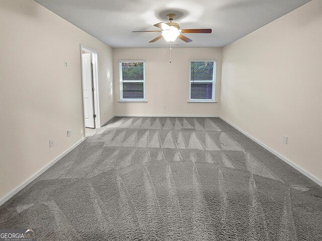 carpeted spare room featuring ceiling fan