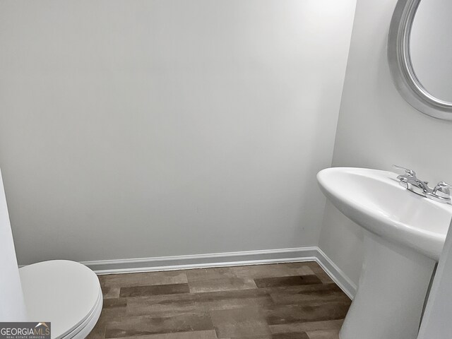 bathroom featuring wood-type flooring and toilet