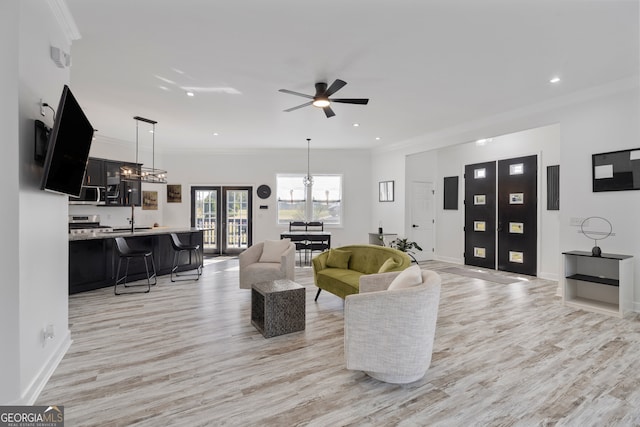 living room with sink, french doors, light hardwood / wood-style floors, ceiling fan, and crown molding