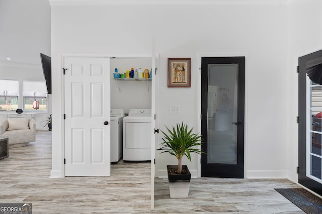 laundry room with washer and dryer and light wood-type flooring