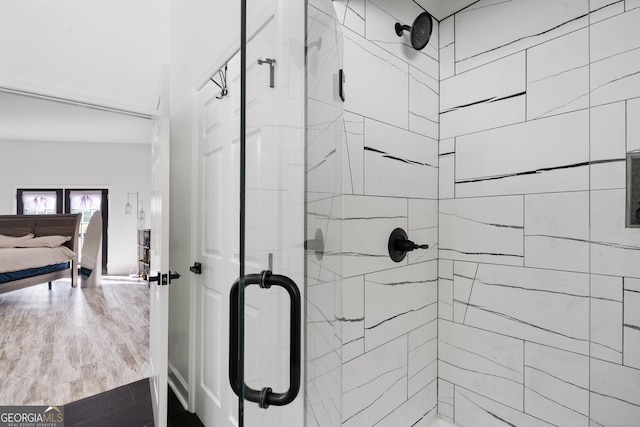 bathroom with a shower with shower door and hardwood / wood-style flooring