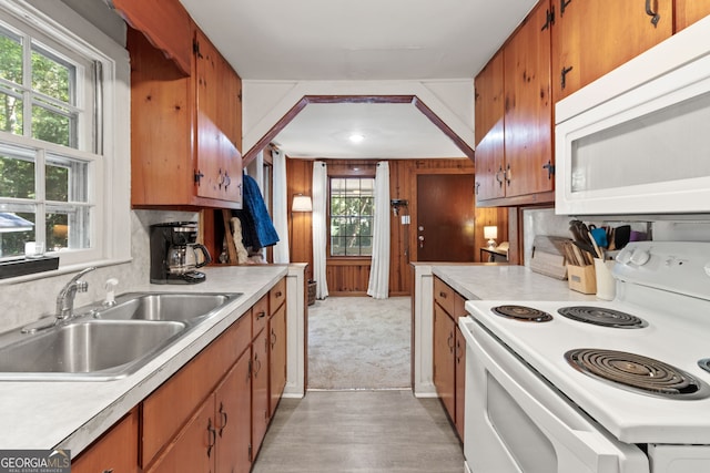 kitchen featuring light wood-type flooring, backsplash, sink, and white appliances