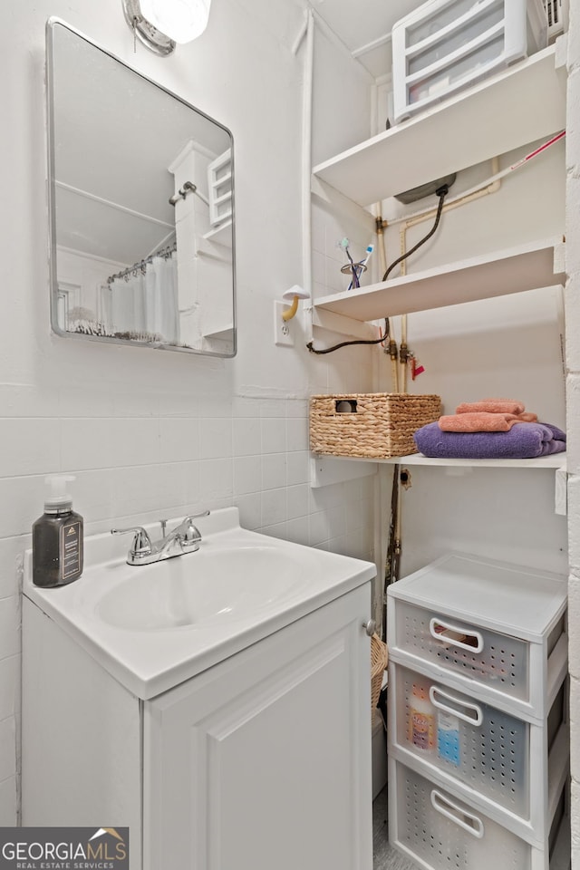 clothes washing area with tile walls and sink