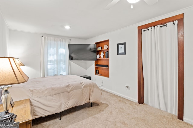 carpeted bedroom featuring crown molding and ceiling fan