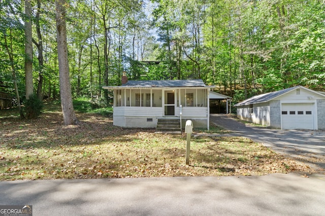 view of front of property with a garage and an outbuilding