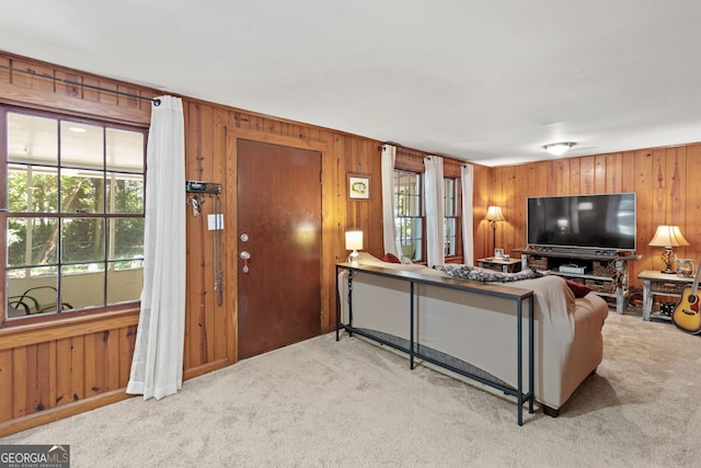 carpeted living room with wood walls