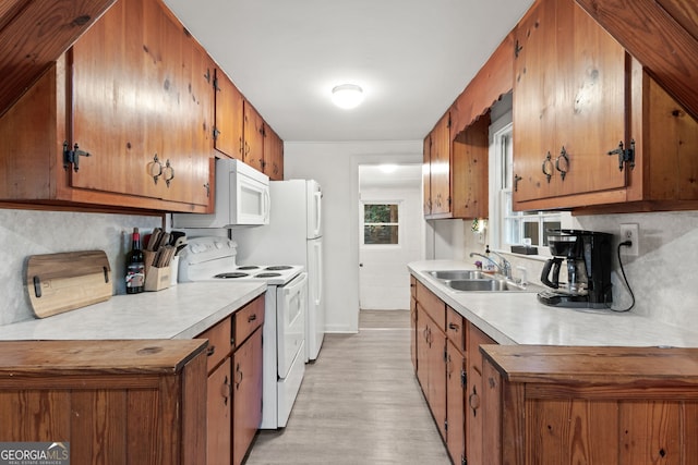 kitchen with sink, backsplash, light hardwood / wood-style floors, and white appliances